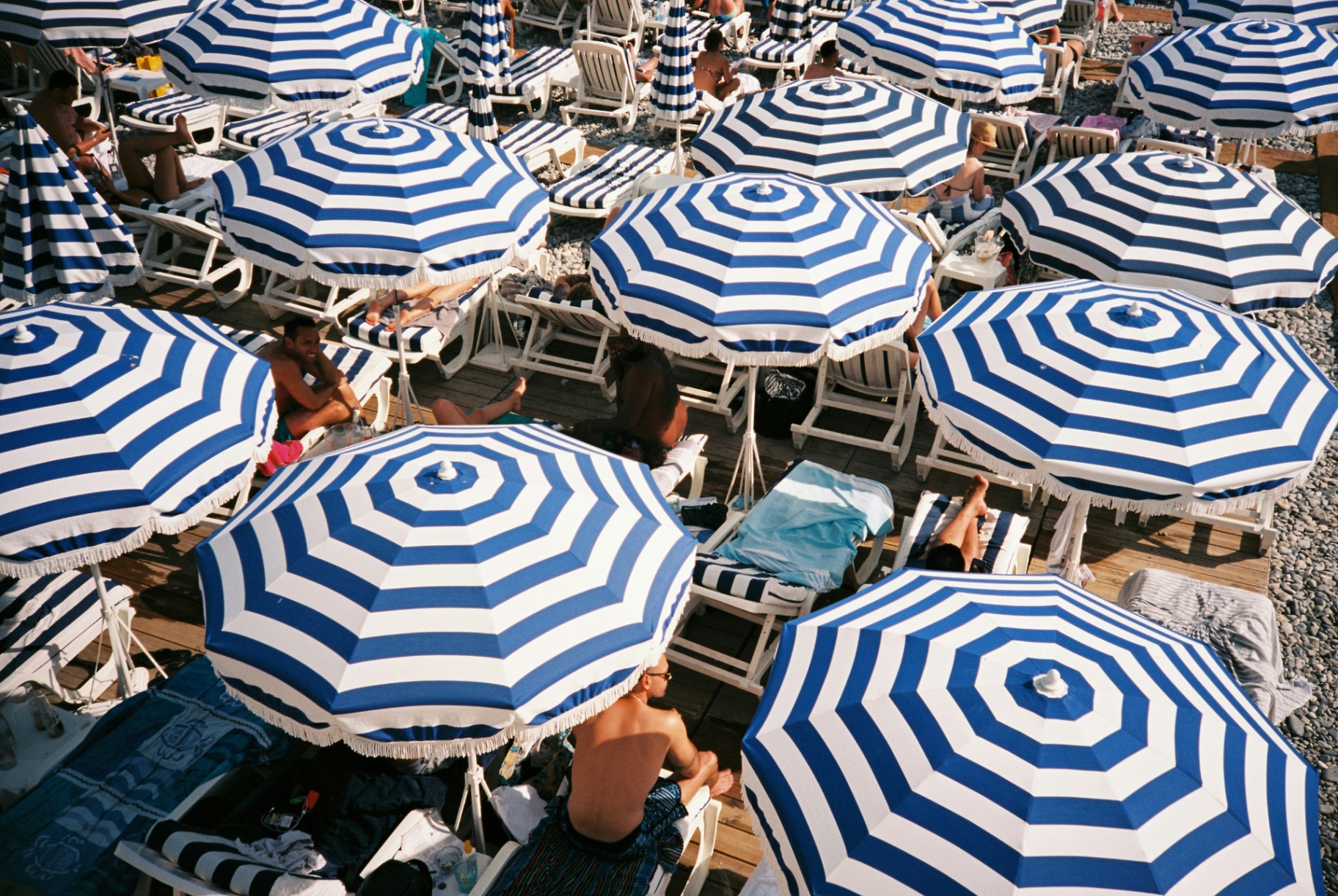 Plage privée de la Côte d'Azur avec parasols rayés bleu et blanc
